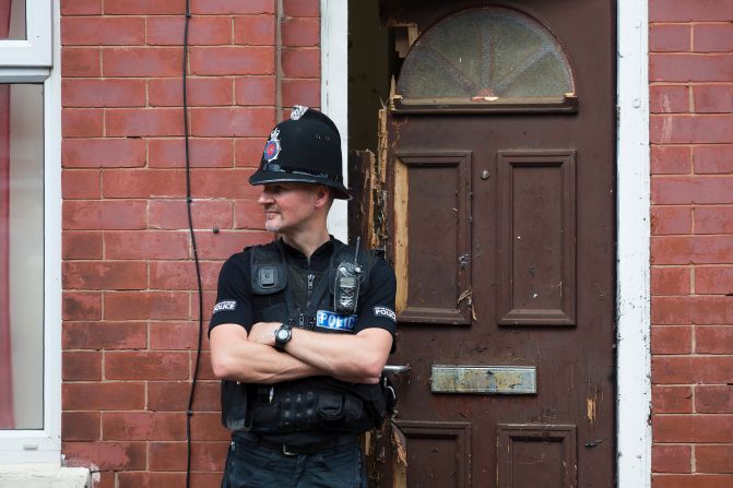A police officer guards a house in Manchester as investigations continued on May 25. Police say a man carrying explosives <a href="index.php?page=&url=http%3A%2F%2Fwww.cnn.com%2F2017%2F05%2F23%2Feurope%2Fmanchester-terror-attack-uk%2Findex.html" target="_blank">acted as a lone attacker</a> and died in the blast.