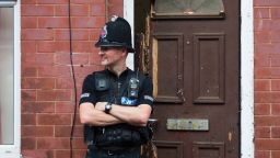 A police officer stands on duty outside a residential property on Lindum Street in Moss Side, Manchester, on May 25, 2017, as their investigations continue into the May 22 terror attack at the Manchester Arena.
Britain Thursday closed in on a jihadist network thought to be behind the May 22, 2017 Ariana Grande concert attack, as grief mixed with anger at the US over leaked material from the probe. Britain has raised its terror alert to the maximum level and ordered troops to protect strategic sites after 22 people were killed in a suicide bomb attack on a Manchester pop concert. / AFP PHOTO / JON SUPER        (Photo credit should read JON SUPER/AFP/Getty Images)