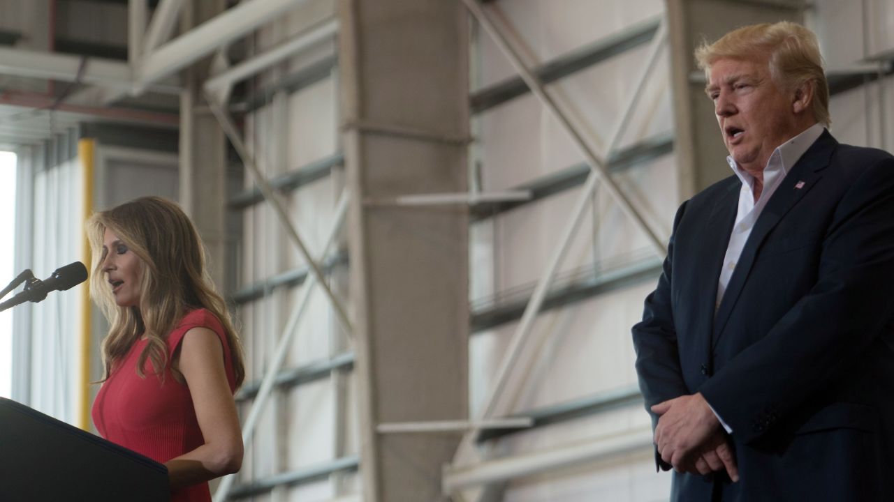 US President Donald Trump listens as his wife, First Lady Melania Trump recites the Lord's Prayer during a rally in Melbourne, Florida on February 18, 2017.