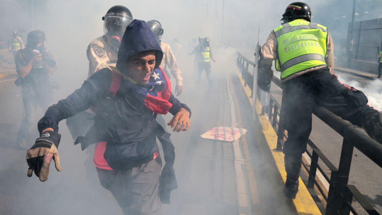 A protester tries to flee from government security forces during a demonstration in Caracas, Venezuela, on Saturday, May 20. Hundreds marched along Caracas' Francisco Fajardo highway, one of the city's major routes, while some flanked a gigantic sign that read "Elections Now" over an overpass. It was the country's <a href="http://www.cnn.com/2017/05/21/americas/venezuela-50-day-protests/" target="_blank">50th consecutive day</a> of anti-government protests.