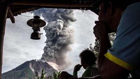 Villagers look on as Mount Sinabung volcano spews thick volcanic ash in Karo, Indonesia, on Friday, May 19. 