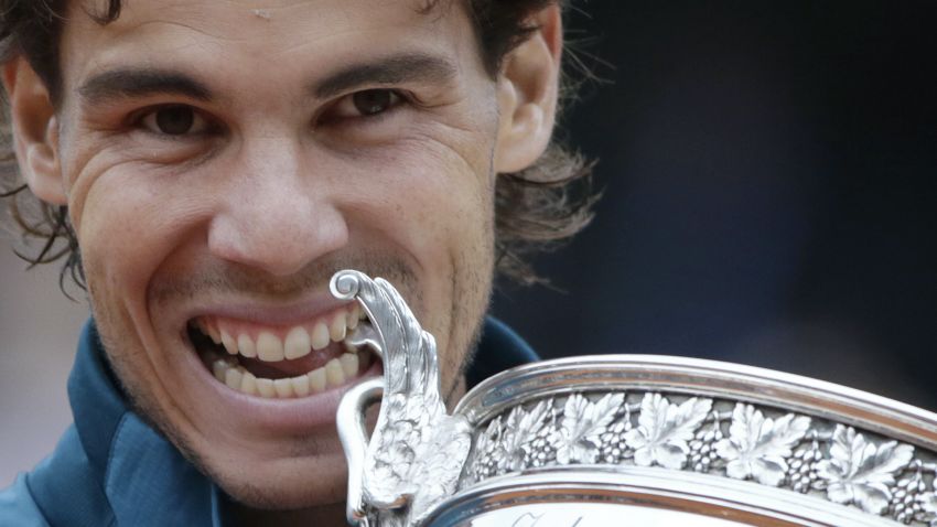 Spain's Rafael Nadal bites the Musketeers trophy after winning the 2013 French tennis Open final against Spain's David Ferrer at the Roland Garros stadium in Paris on June 9, 2013. AFP PHOTO / KENZO TRIBOUILLARD        (Photo credit should read KENZO TRIBOUILLARD/AFP/Getty Images)