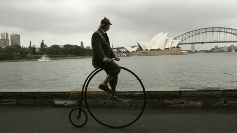 SYDNEY, AUSTRALIA - DECEMBER 2:  Lloyd Scott rides his Penny Farthing bicycle in front of the Harbour Bridge during the final day of a cycling trip from Perth to Sydney December 2, 2004 in Sydney, Australia. Scott, a well known British fundraiser and leukaemia survivor, completed the 4,300 km trip in a bid to raise money for a leading UK charity named Children with Leukaemia.  (Photo by Patrick Riviere/Getty Images)