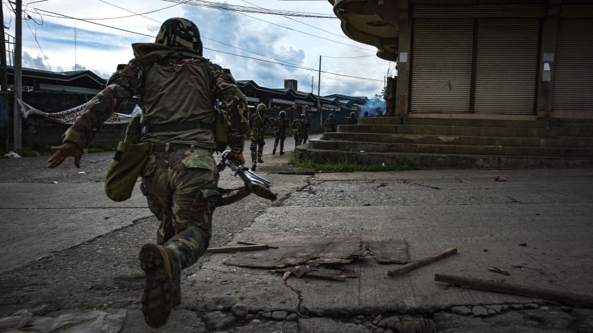 MARAWI CITY, PHILIPPINES - MAY 25: Soldiers run for cover to evade sniper fire while trying to clear the city of armed militants, one street at a time, on May 25, 2017 in Marawi city, southern Philippines. Gun battles between ISIS-linked militants and Filipino troops erupted in Marawi city on Tuesday when gunmen from the local terrorist groups Maute Group and Abu Sayyaf rampaged through the southern city, prompting President Rodrigo Duterte to declare 60 days of martial law in Mindanao. Thousands of residents were reported to have fled from Malawi city while at least 21 people were killed, including a police chief who had been beheaded and buildings were torched by the terror groups. President Duterte said the influence of Islamic State is one of the nation's top security concerns, and martial law on Mindanao island could be extended across the Philippines to enforce order, allowing the detention of people without charge. (Photo by Jes Aznar/Getty Images)