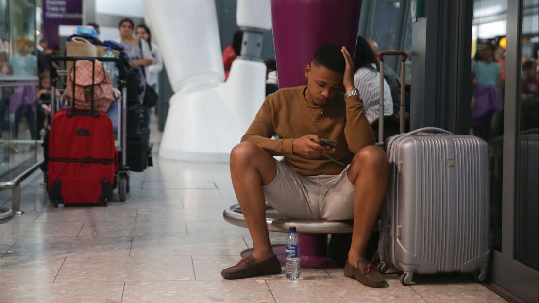 A traveler waits at Heathrow Airport Terminal 5 after British Airways flights were cancelled at Heathrow Airport.