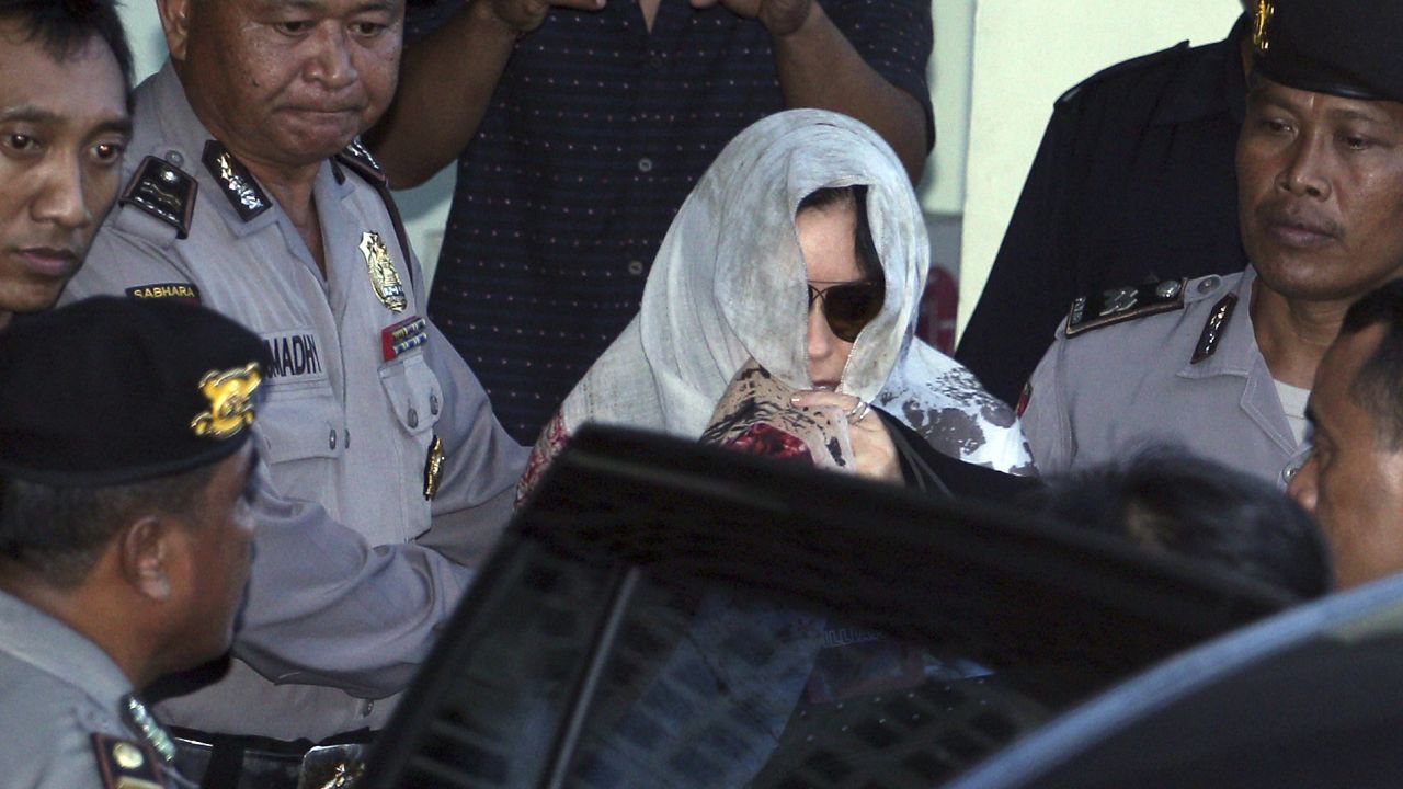 Schapelle Corby covers her head as she leaves the parole office in Bali, Indonesia, on Saturday.