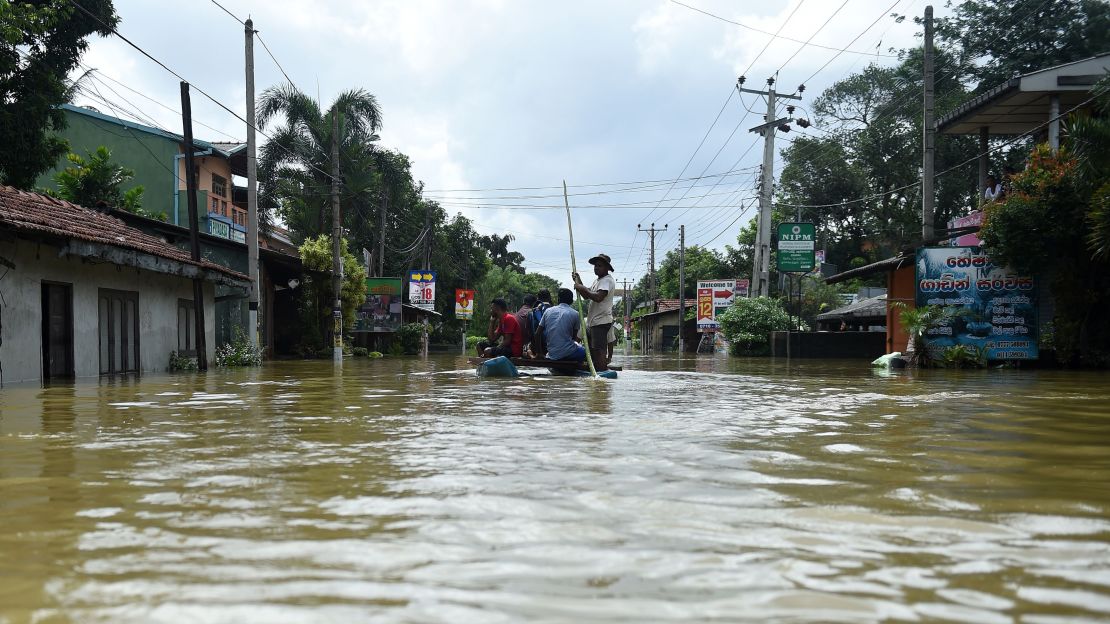 Sri Lankan residents travel by boat through floodwaters in the suburb of Kaduwela in the capital Colombo.