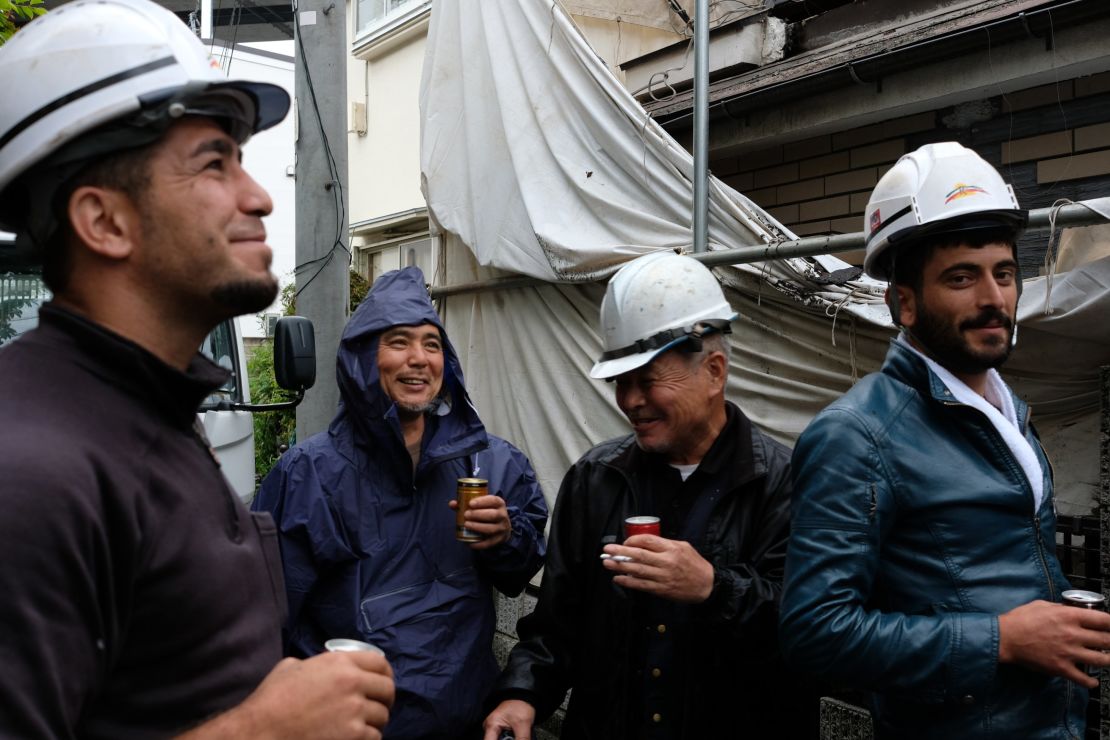 Yuichi Aoki (left) takes a break from demolishing a house in Saitama, Japan.