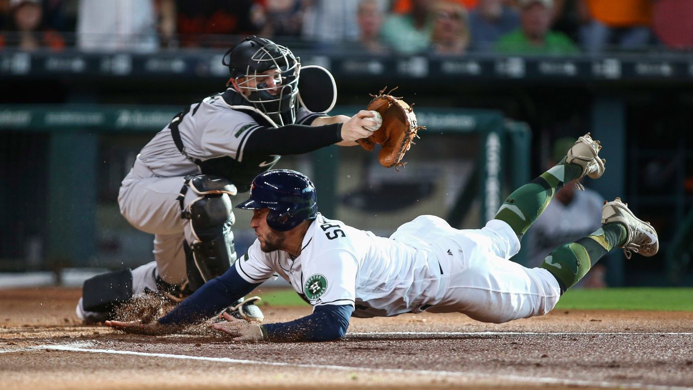 Houston's George Springer slides under Baltimore catcher Caleb Joseph during a Major League Baseball game in Houston on Saturday, May 27.