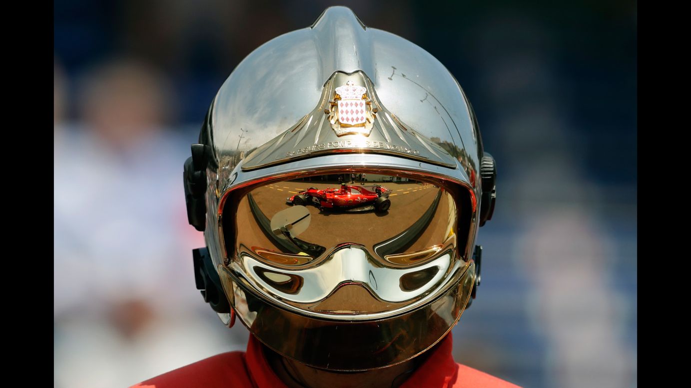 The Formula One car of Kimi Raikkonen is reflected on a firefighter's helmet during practice in Monaco on Thursday, May 25.