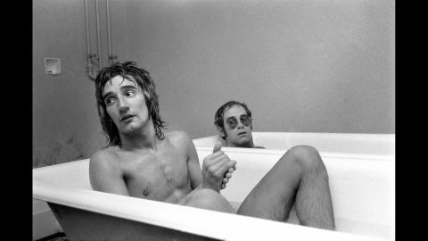 John and singer Rod Stewart have a bath at the stadium of Watford Football Club in 1973. John, a lifelong Watford fan, later owned the English soccer club. Today, one of the stadium's stands is named after him.