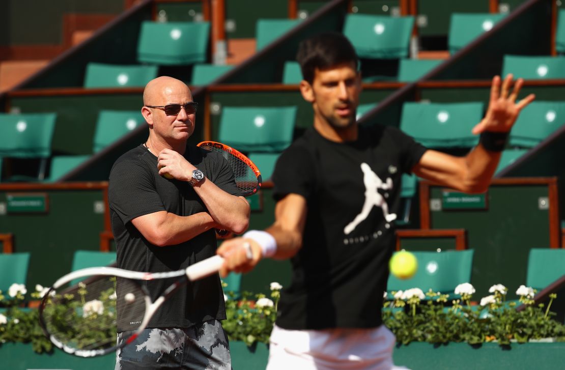 Agassi watches on during a Djokovic training session.