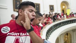 Pedro Paredes joins hundreds of protesters lining the balconies of the state Capitol rotunda in Austin on Monday May 29, 2017, the last day of the legislative session, to protest Senate Bill 4, legislation already passed by Texas Gov. Greg Abbott that compels local police to enforce federal immigration law. (Ricardo Brazziell/Austin American-Statesman via AP)