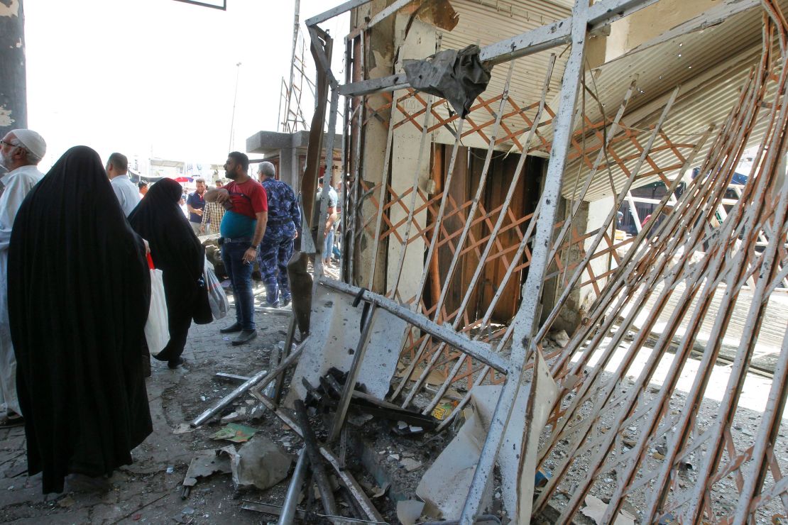Iraqis gather at the site of a car bomb explosion near Baghdad's General Retirement Department.