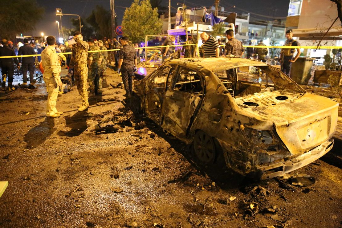 People gather around the blast site early Tuesday. 