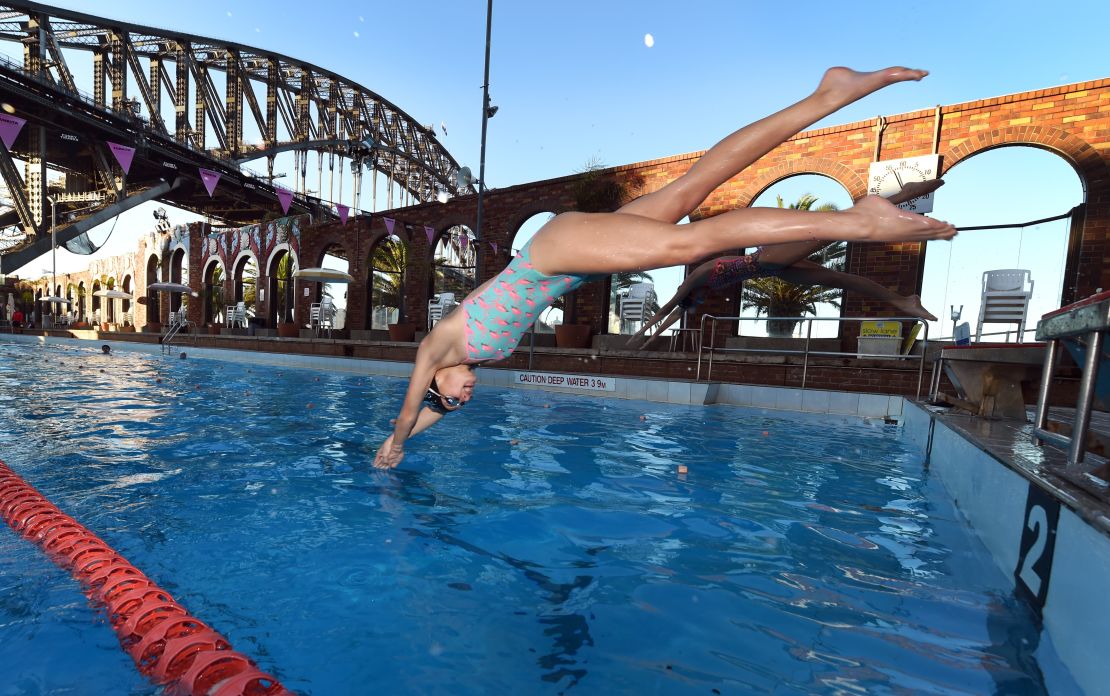 Swimmers dive into the North Sydney Olympic Pool.