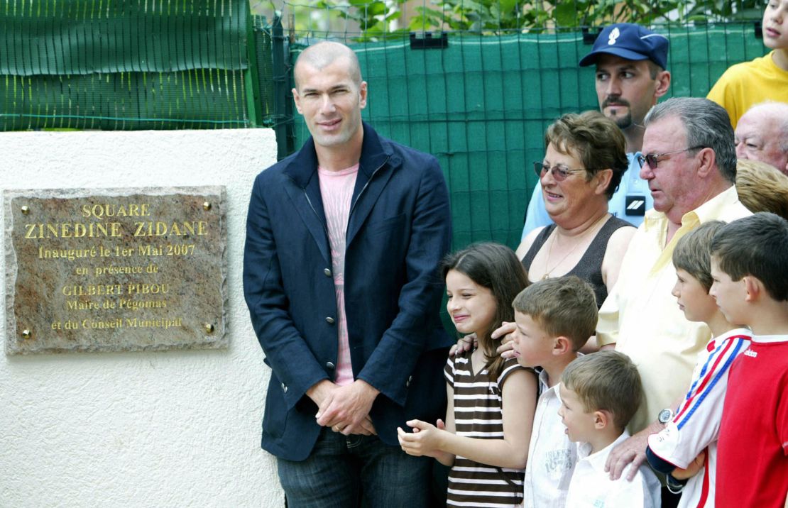 Zinedine Zidane (L) poses next to former hosts Jean-Claude (R, second row) and Nicole Elineau (Second from right, second row) during a naming ceremony of a square in Pegomas, France, in May, 2007. The couple hosted Zidane while he was a youth player with AS Cannes in 1987. 