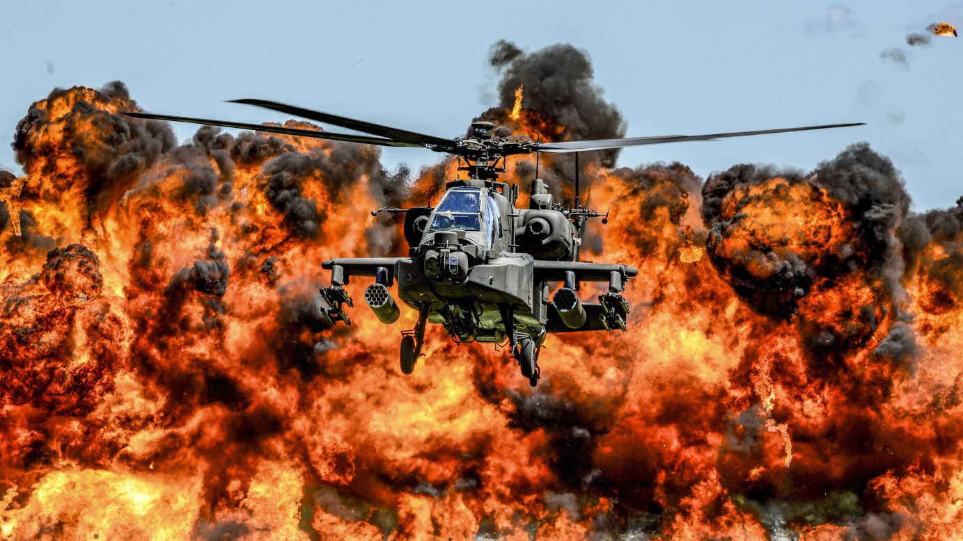 An AH-64D Apache attack helicopter flies in front of a wall of fire Saturday, May 6, during the South Carolina National Guard's Air and Ground Expo. The fire was part of the demonstration.
