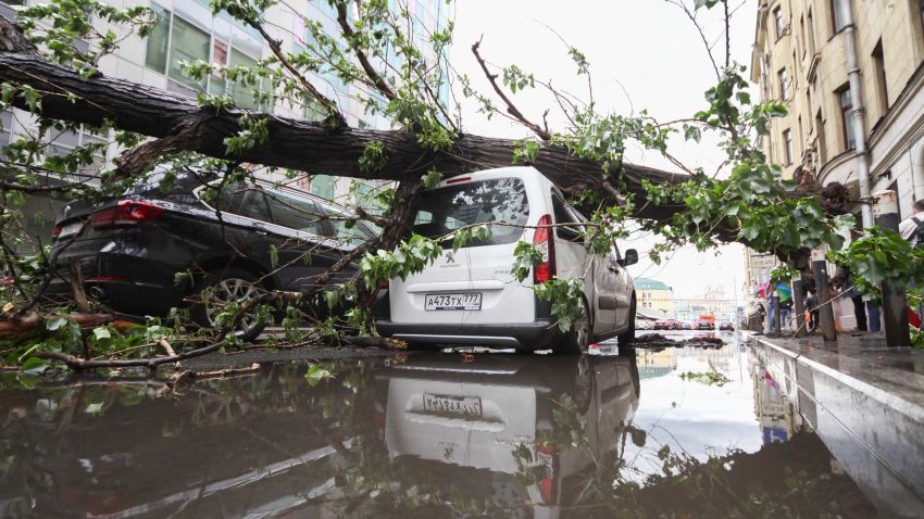 In this Monday, May 29, 2017 photo vehicles are covered with a fallen tree following a storm, in a residential area of Moscow, Russia. Thunderstorms and strong winds buffeted Moscow and its surrounding areas on Monday, killing 11 people and injuring dozens, Russian officials said.
 (Sergey Vedyashkin/Moscow News Agency photo via AP)