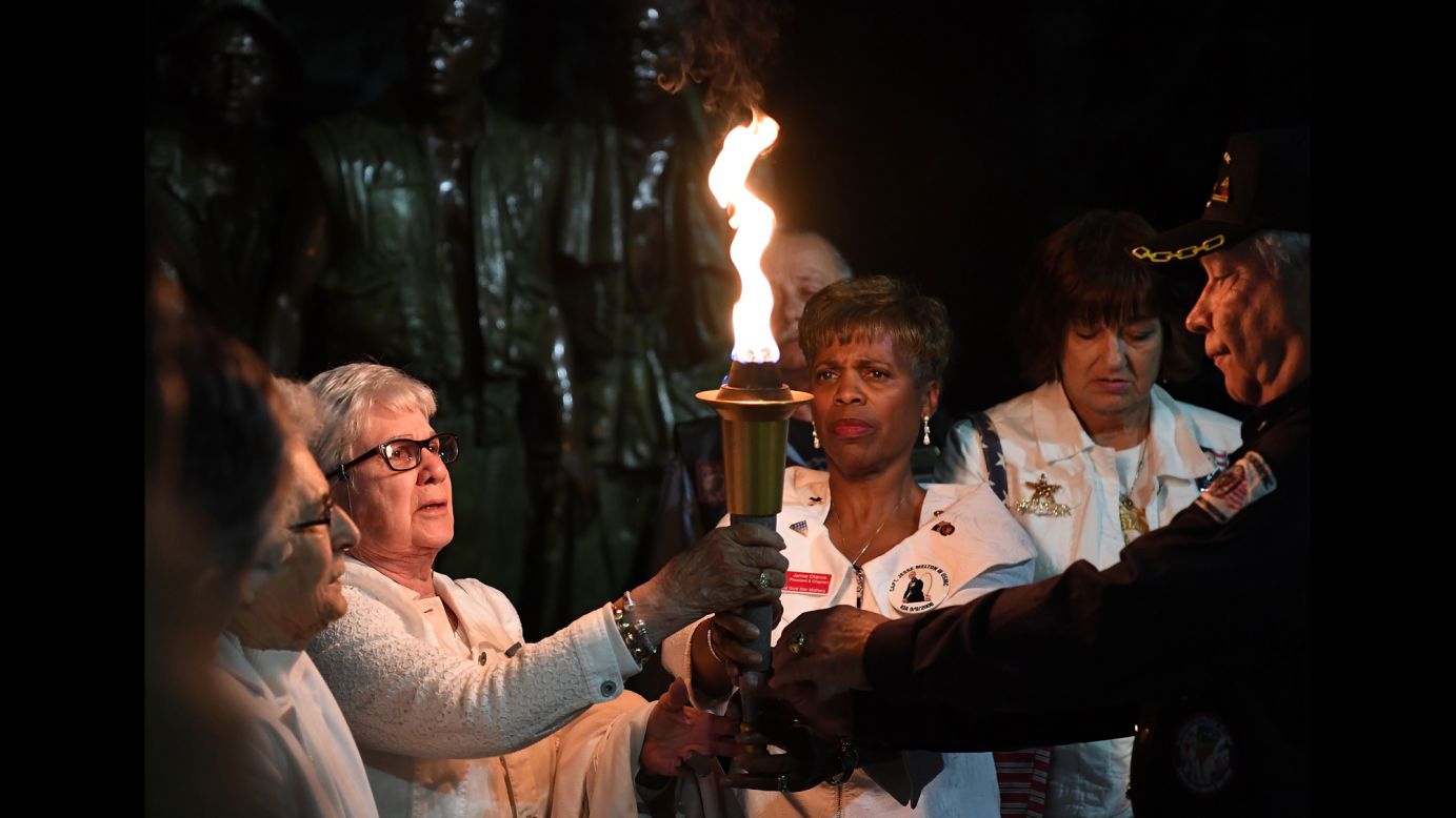 Gold Star Mothers and their supporters hold a torch as they recite the names of their fallen children during a candlelight vigil in Washington on Friday, May 26.