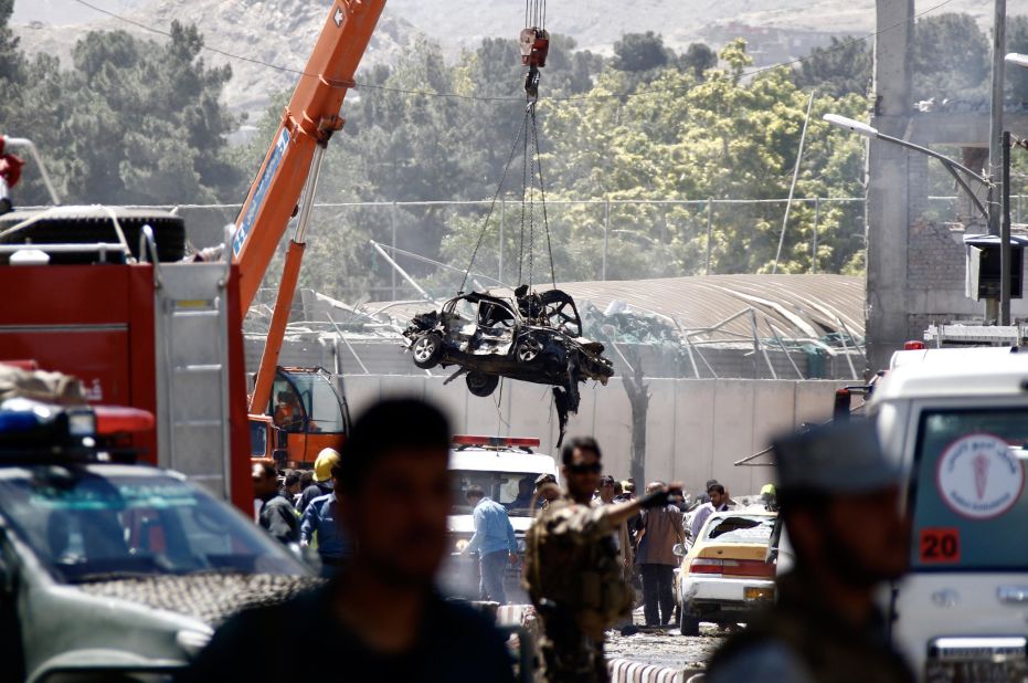 A mangled vehicle is lifted out of the wreckage after  the explosion.