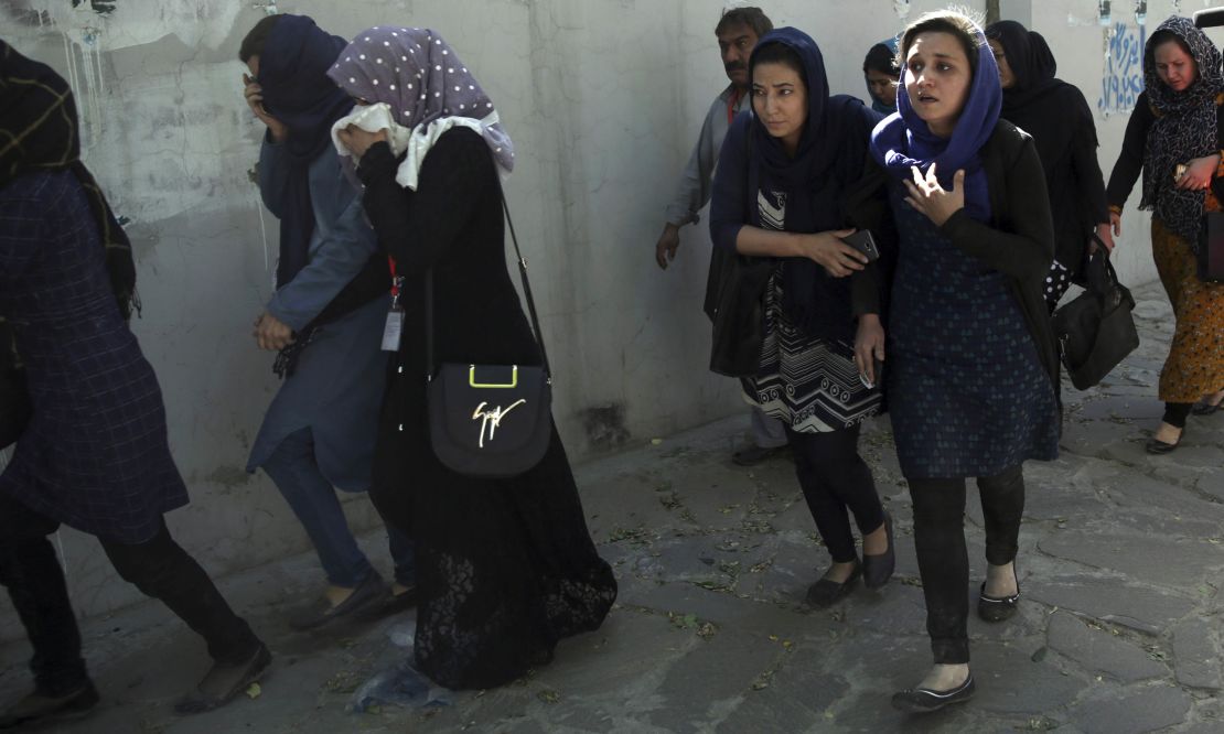 Roshan mobile company employees leave the site of the attack in Kabul on Wednesday.