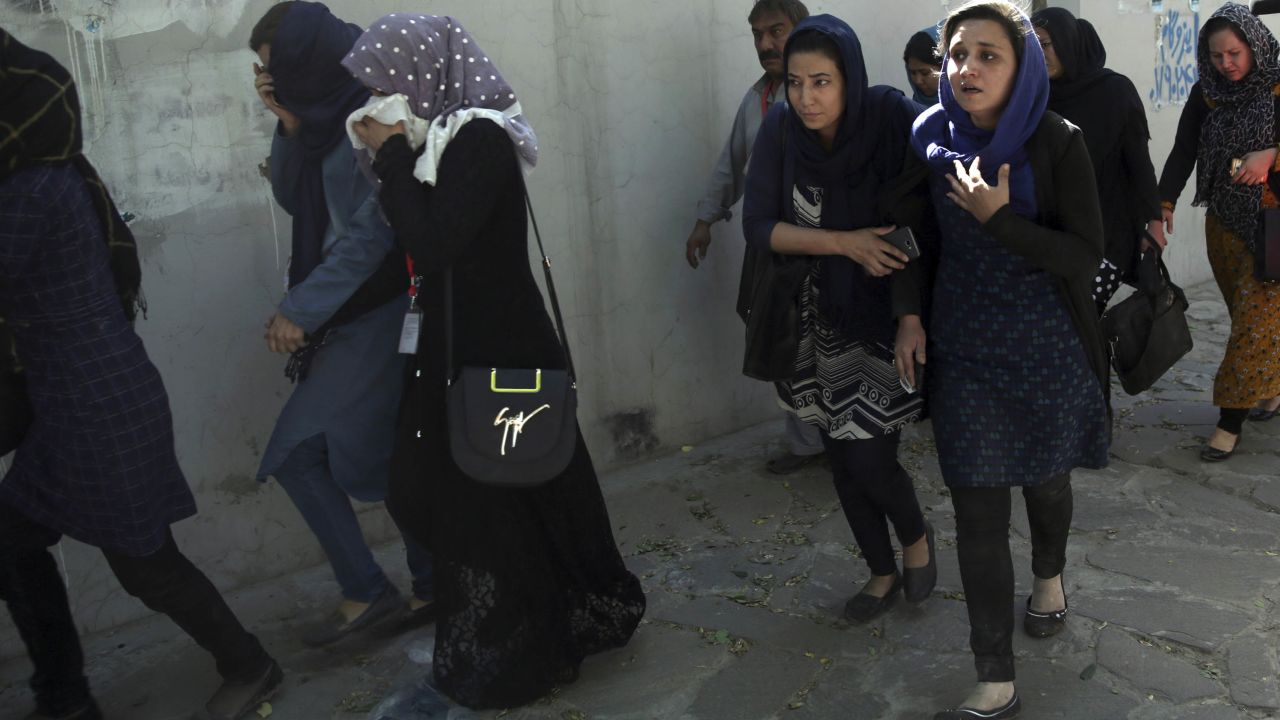 Roshan mobile company employees leave the site of the attack in Kabul on Wednesday.