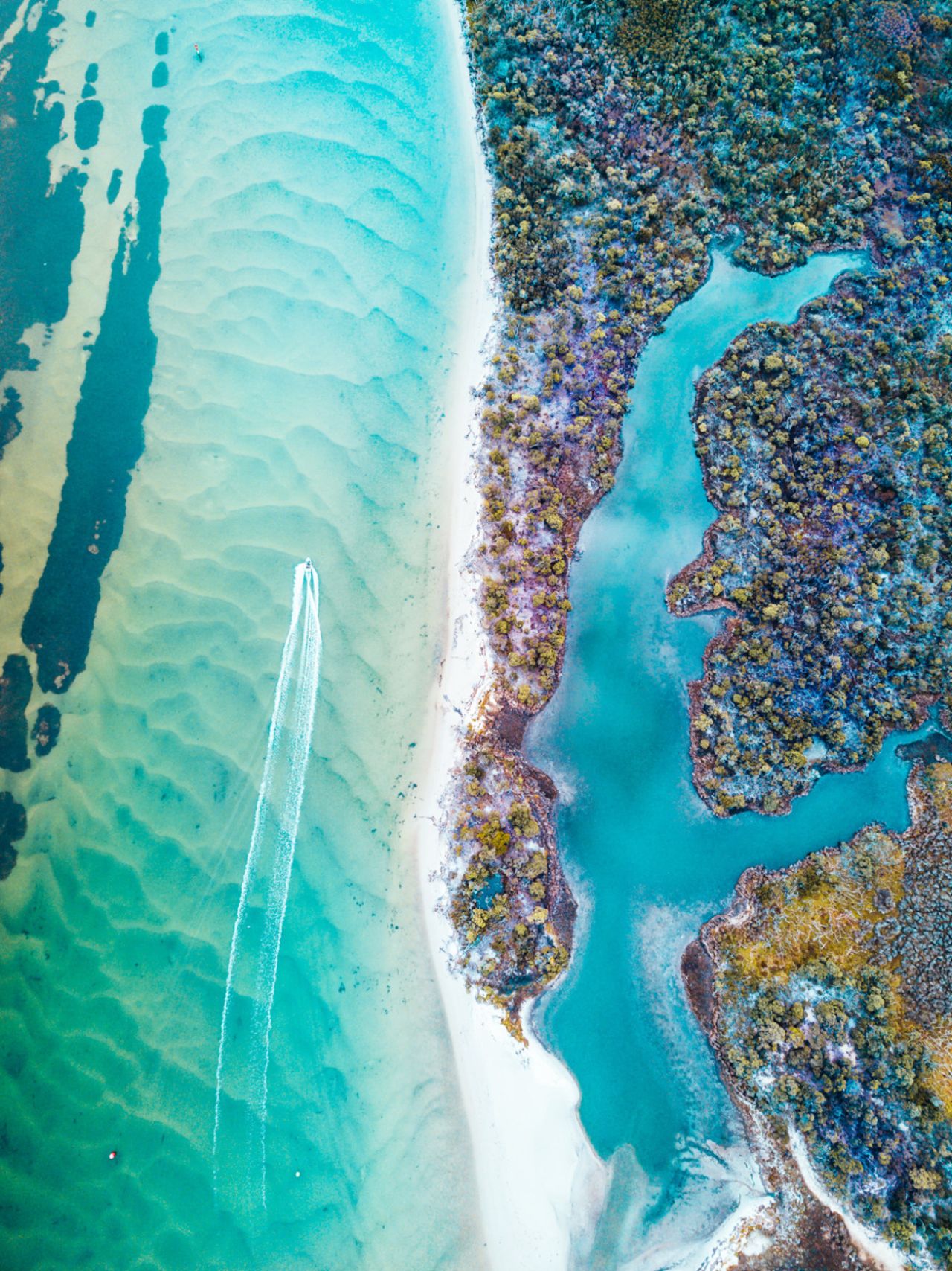 <strong>Rigby Island, Victoria: </strong>"The vivid turquoise and sculptural shapes are astounding; it seems almost abstract, then all the lines drive your view to the almost invisible boat leaving a broad wake," said judges of the third prize winner, by photographer <a href="https://www.skypixel.com/user/pyan" target="_blank" target="_blank">Peter Yan</a>.  
