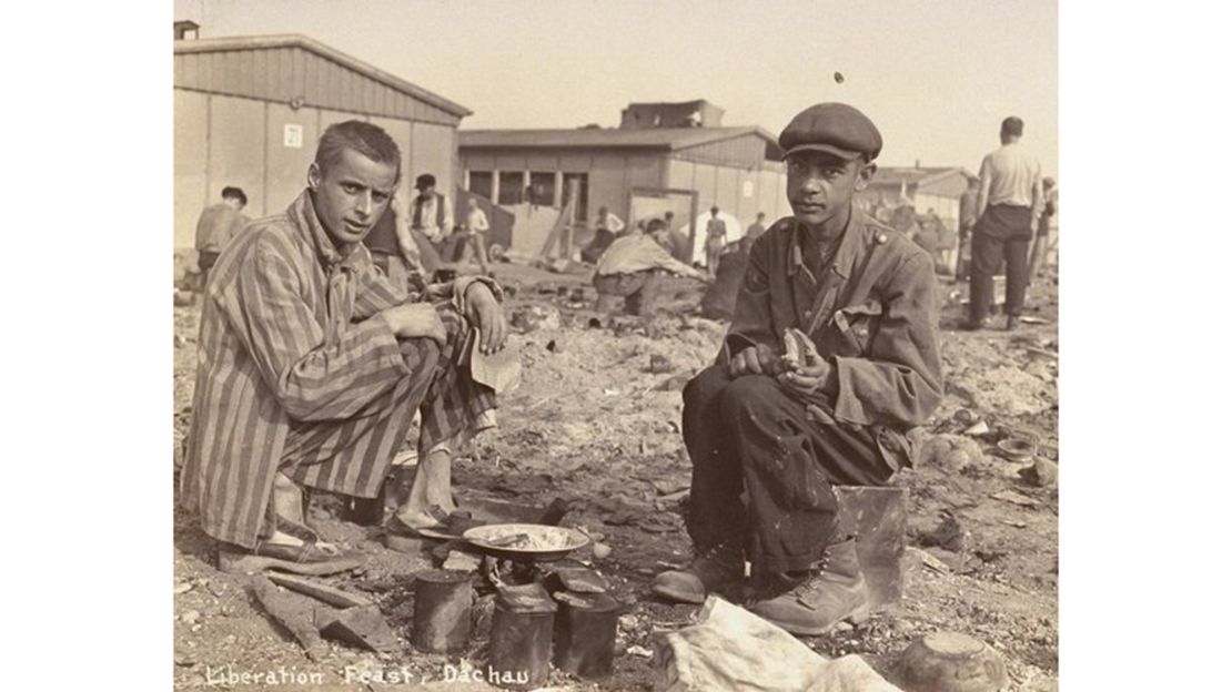 Caption: Two survivors prepare food outside the barracks. The man on the right is thought to be Jean (Johnny) Voste, born in Belgian Congo -- the only black prisoner in Dachau. 
Photo Credit: United States Holocaust Memorial Museum, courtesy of Frank Manucci. 
Date: May 1945
