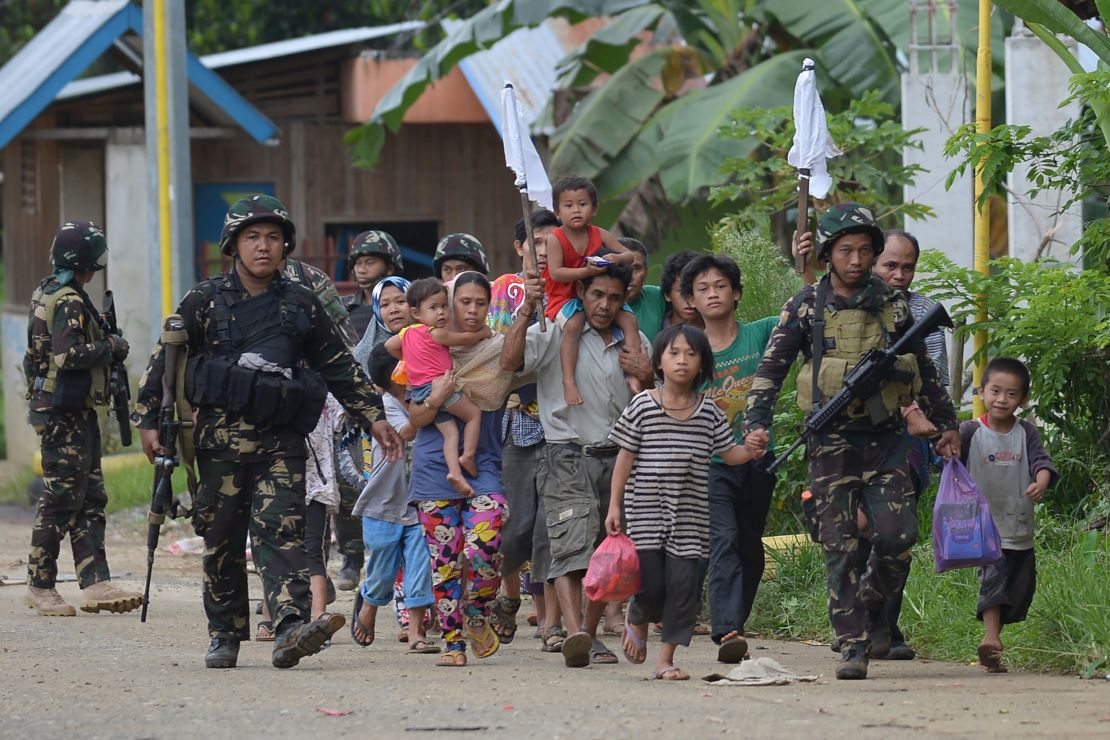 Philippine troops escort rescued civilians at a village on the outskirts of Marawi on May 31.