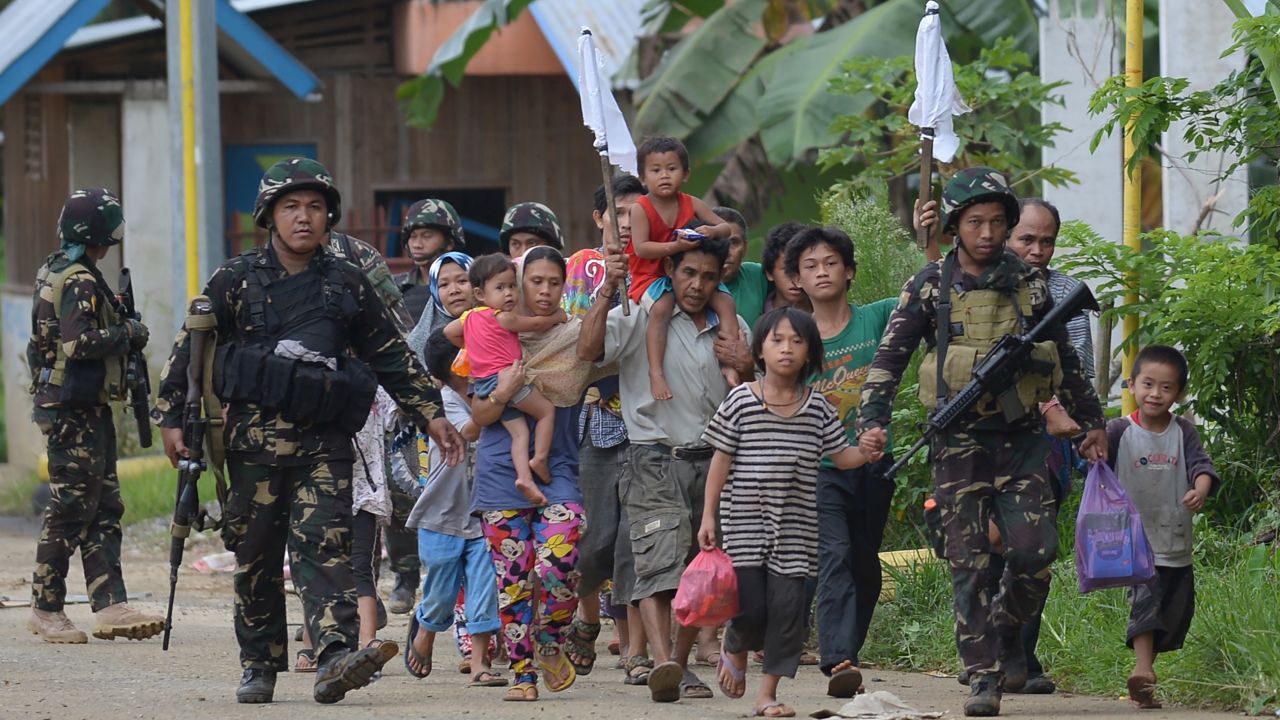 Philippine troops escort rescued civilians at a village on the outskirts of Marawi on May 31.