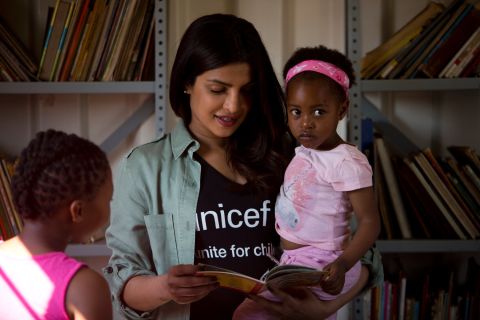 On May 7, 2017 in South Africa, UNICEF Goodwill Ambassador Priyanka Chopra reads a story to 3-year-old Sindiduringa, in her arms, while an older girl listens, in the children's library at the Isibindi Safe Park in Soweto Township, in the city of Johannesburg. Photo/Unicef/Karel Prinsloo