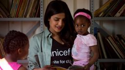 On May 7, 2017 in South Africa, UNICEF Goodwill Ambassador Priyanka Chopra reads a story to 3-year-old Sindiduringa, in her arms, while an older girl listens, in the children's library at the Isibindi Safe Park in Soweto Township, in the city of Johannesburg. Photo/Unicef/Karel Prinsloo

