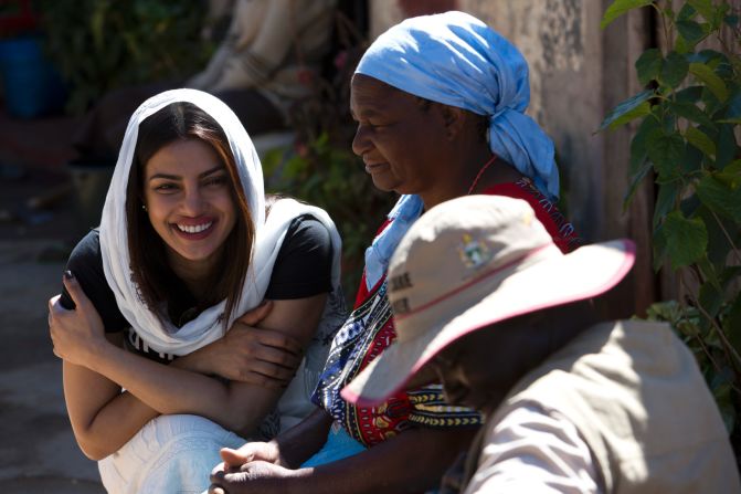 UNICEF Goodwill Ambassador Priyanka Chopra (left) speaks with Sarah Sitole, 58, (back right) who cares for her two grandchildren and who received assistance from a Community Childcare Worker in Epworth, Zimbabwe. Community Childcare Workers (CCWs) are volunteers who play a critical role by being the "eyes and ears" for social workers in communities and were set up to assist with the management of child welfare, in response to the limited number of social workers available. 