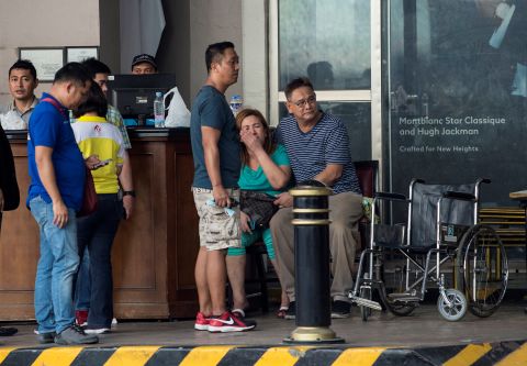 Relatives of a victim sit in front of the Resorts World Hotel, a popular tourist site in Manila, the capital of the Philippines that was on lockdown after a shooting on June 2, 2017. A police official said the incident was a robbery attempt by one person and not a terrorist attack.