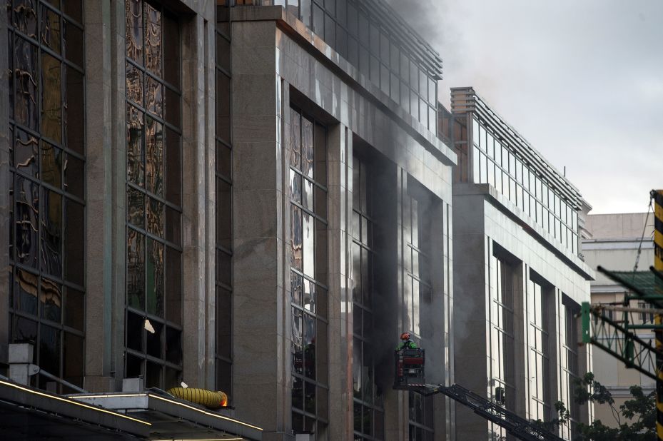 Firemen break a glass window of the Resorts World Hotel following the assault.