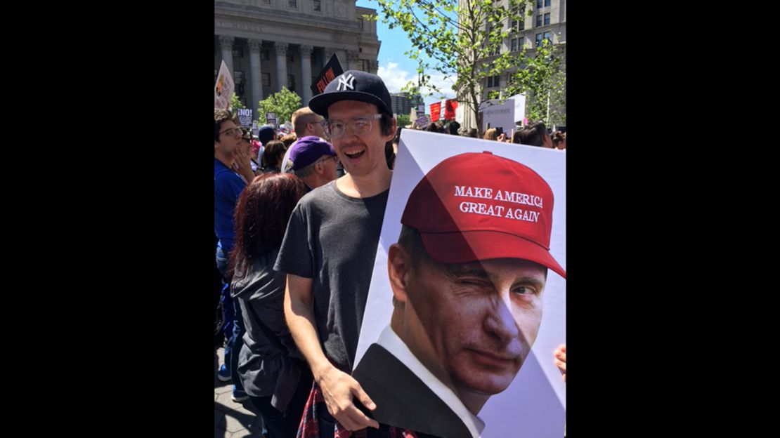 Jake Rowland holds a sign with an image of Russian President Vladimir Putin wearing a Trump campaign "Make America Great Again" cap at New York protest.    