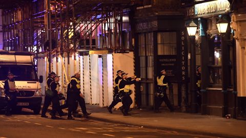 Armed police advance towards a pub in Borough High Street at London Bridge.