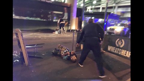 Image from London's Borough Market shows two people lying on the road. Police activity is visible nearby.