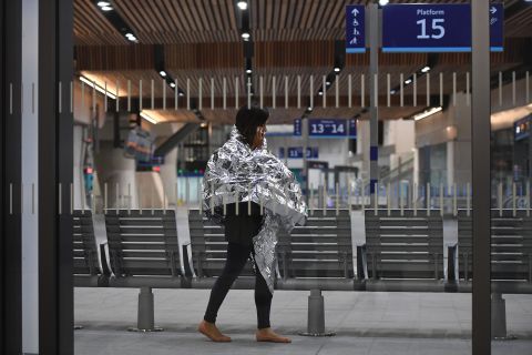 A woman wearing an emergency blanket talks on her phone at London Bridge train station. London Bridge Tube station was closed and London Bridge was closed in both directions.