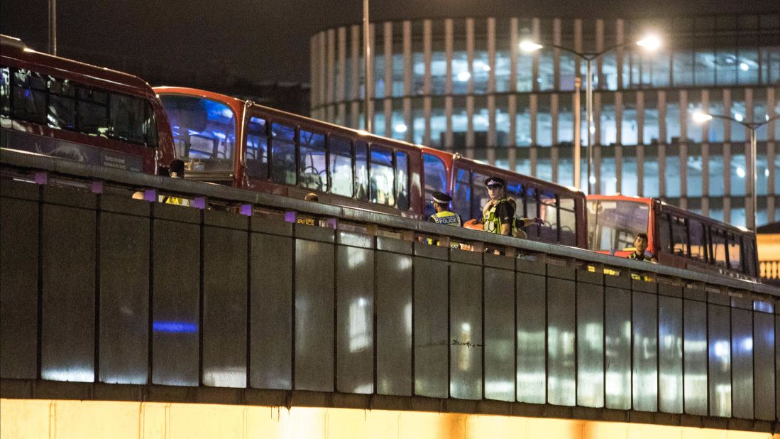 Police carry out a search near empty buses on London Bridge, Saturday, June 3.