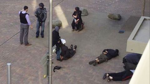 People lie on the ground after being detained by police at Elizabeth Fry apartments in Barking, east London, which officers raided Sunday, June 4, following Saturday's terror attack at London Bridge and Borough Market. 