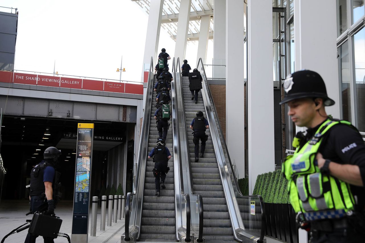 Counter terrorism officers move up an escalator under The Shard, an iconic highrise near the scene of last night's London Bridge attack.