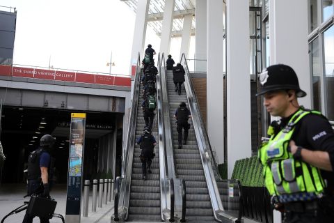Counter terrorism officers move up an escalator under The Shard, an iconic highrise near the scene of last night's London Bridge attack.