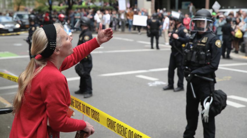 PORTLAND, OR - JUNE 04:  A protester gestures toward police on June 4, 2017 in Portland, Oregon. Pro-President Trump and counter protests are taking place in the wake of the stabbing deaths of Ricky Best, 53, and Taliesin Namkai-Meche, 23, severe injuries to Micah Fletcher,21, after they tried to protect two teenage girls, one of whom was wearing a hijab, from being harassed with racial taunts by suspect Jeremy Christian.  (Photo by Scott Olson/Getty Images)