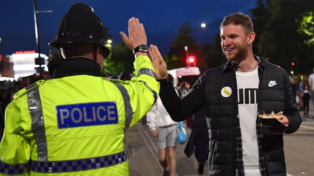 A fan high-fives a police officer as fans leave the concert. 