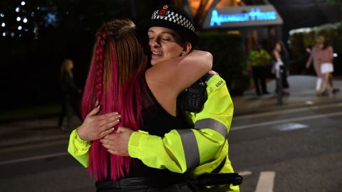 A music fan hugs a police officer as fans leave Old Trafford Cricket Ground after the benefit concert for the families of the victims of the May 22, 2017 Manchester terror attack. 