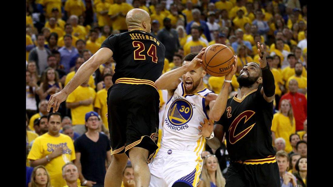 Curry drives to the hoop against Richard Jefferson, left, and Irving.