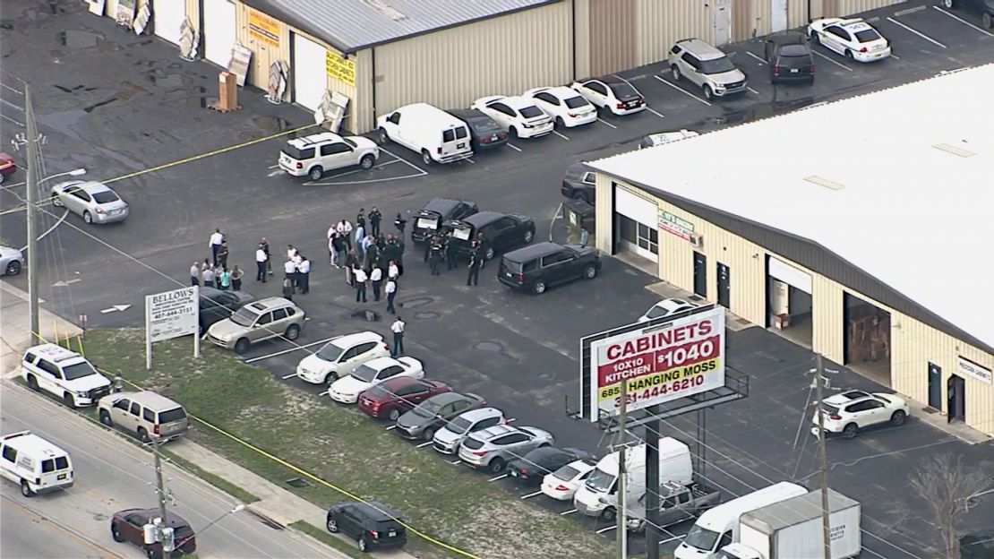 Officers gather in an industrial district of suburban Orlando, where multiple people were killed.