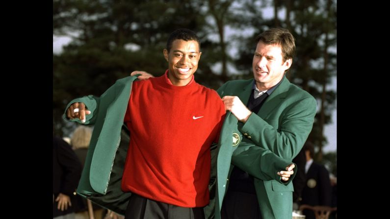 Over four days in Augusta, Georgia, in April 1997, golf's next great champion announced his arrival in record-breaking fashion. At age 21 and 3 months, <a href="index.php?page=&url=http%3A%2F%2Fwww.cnn.com%2F2013%2F05%2F30%2Fus%2Ftiger-woods-fast-facts%2Findex.html">Tiger Woods </a>became the youngest player to win the Masters, after posting a record-low score of 18-under par. Here, 1996 Masters champion Nick Faldo helps Woods into his new green jacket.